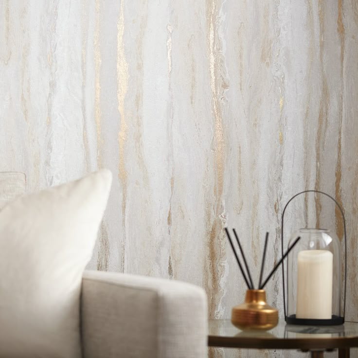 Elegant living room wall with textured lime-based plaster featuring gold accents, paired with a neutral sofa and minimalist decor.