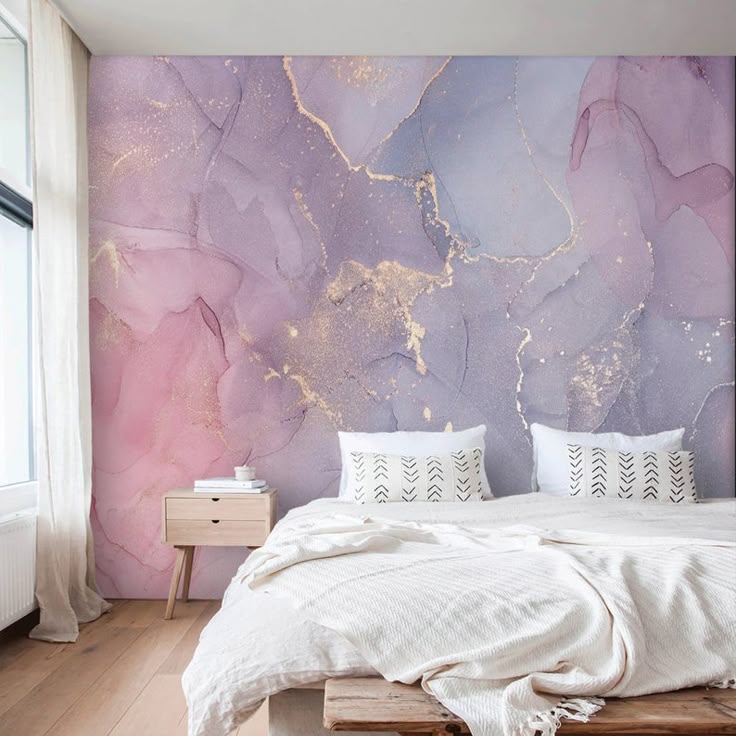 Luxurious bedroom featuring a statement wall with watercolor-inspired plaster in pink, purple, and gold tones.