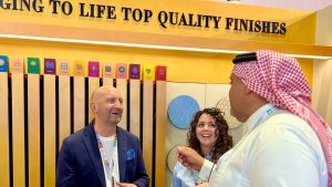 Decora representatives interacting with a client at an event, showcasing top-quality finishes.