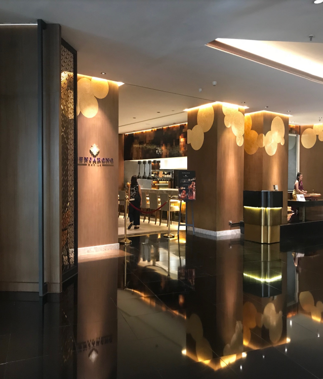 Luxurious hotel lobby with golden decorative panels and a modern dining area.