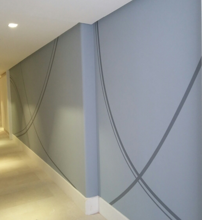 Modern hallway with a blue wall featuring abstract curved line patterns.