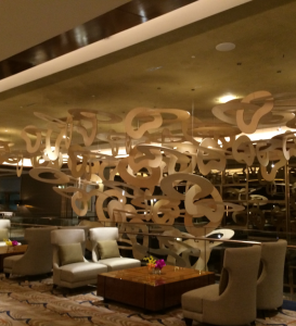 Contemporary hotel lounge with abstract ceiling installation and plush seating.