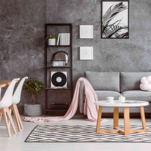 Modern living room with a gray textured wall, Scandinavian-style decor, and pastel accents.