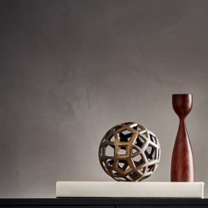 Minimalist decor with geometric metal sphere and wooden sculpture on a modern shelf.