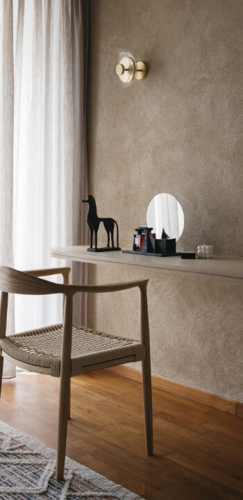 Minimalist vanity space with a textured lime-based painted wall in warm earthy tones.
