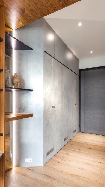 Modern hallway with concrete-textured walls and wooden shelving, suitable for lime-based painting applications.