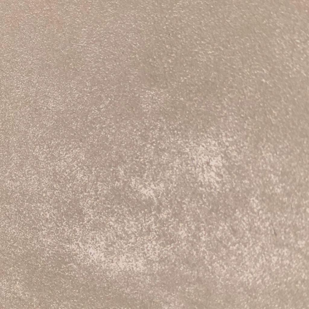 Close-up of beige plaster wall with subtle cloudy texture and matte finish.