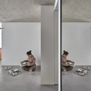 Person Reading a Magazine in a Minimalist Interior with Reflections