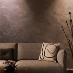 Cozy Sofa with Abstract Pillow Against Textured Wall