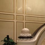 Elegant staircase with gold-trimmed wall panels and decorative railing