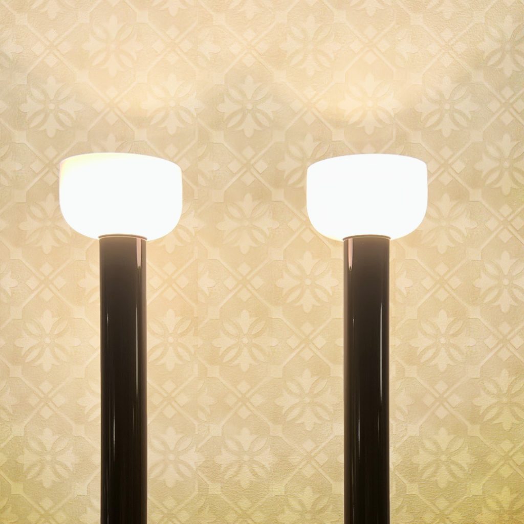 Two modern lamps against a textured floral wall, depicting an unrefined space before transformation.
