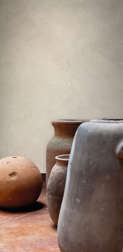 Clay pots in various sizes against a textured beige wall, representing a space ripe for transformation.
