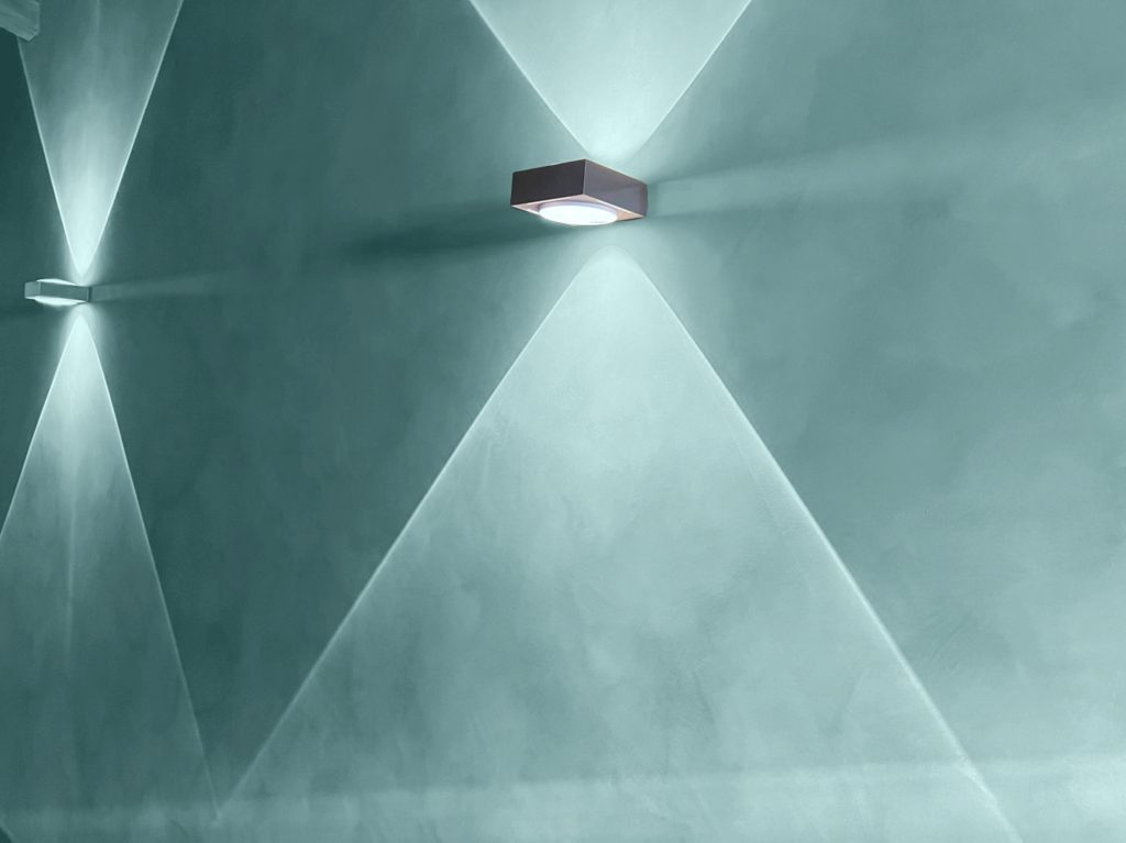 Textured wall with soft lighting creating geometric shapes and shadows