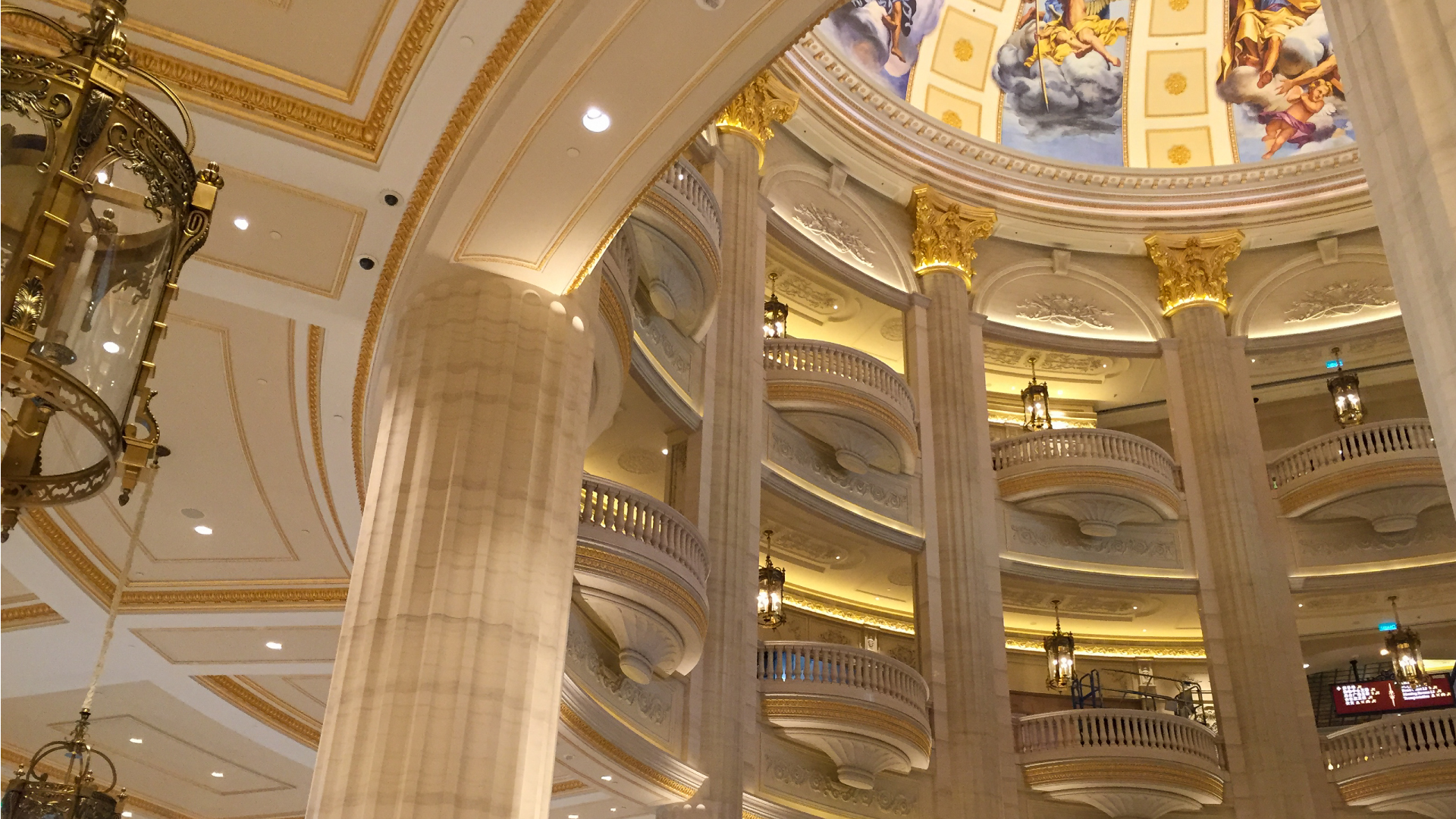 Ornate interior of a grand building with intricate columns and ceiling murals