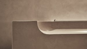 Simple and elegant lime-based plaster design showcasing smooth curves on a textured wall surface.