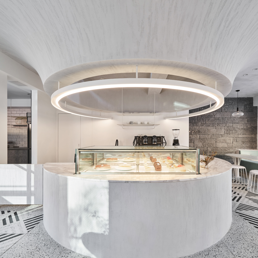 Modern cafe interior with a circular display counter and a minimalist design.