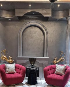 Bold luxury interior with Decora’s decorative metallic wall paint and sand-textured metallic wall finish behind sculptural arches and columns.