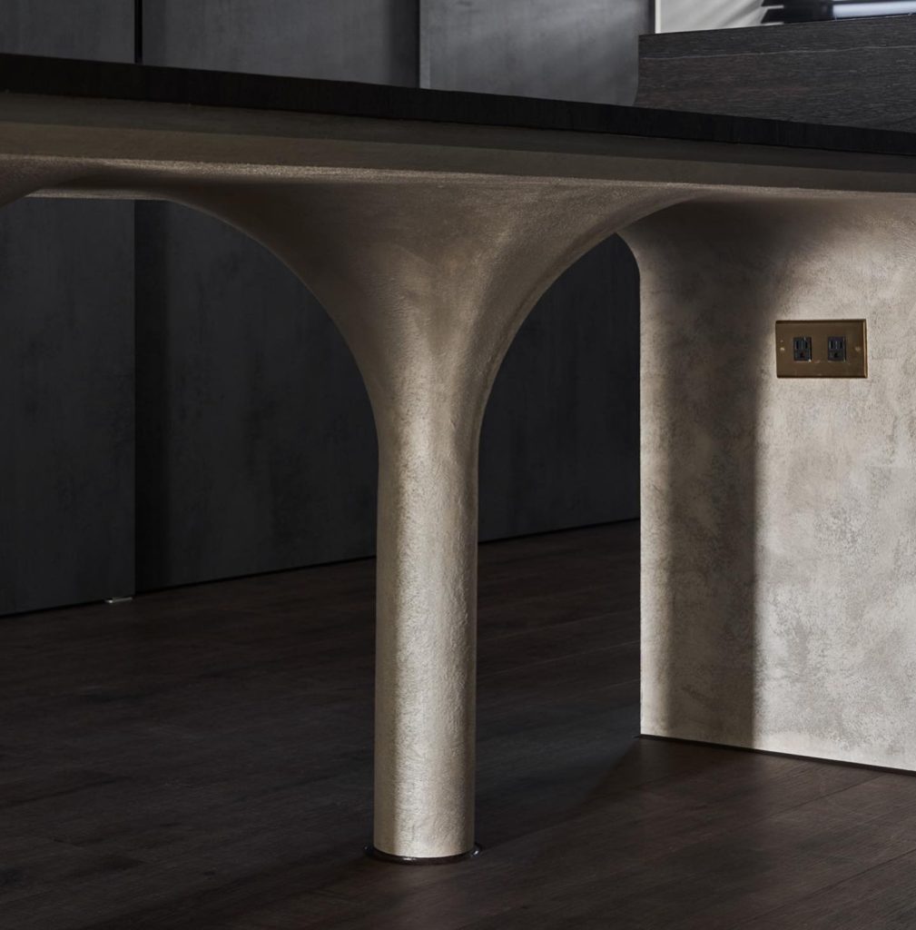 A sculptural kitchen island base finished with Era by Decora’s luxury metallic wall paint, showcasing a 3D textured sheen against a modern dark interior.