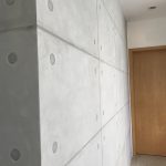 Modern interior wall with lime-based painting finish by specialty contractors, designed to mimic raw concrete panels.