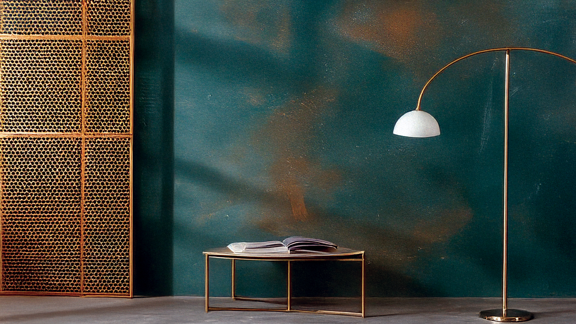 Modern living space featuring lime-based paint on a textured wall with brass furniture elements.