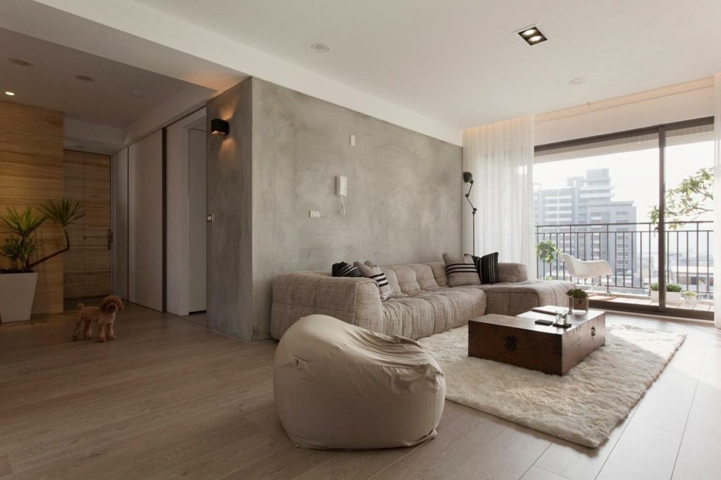 Modern living room with polished plaster accent wall and natural light