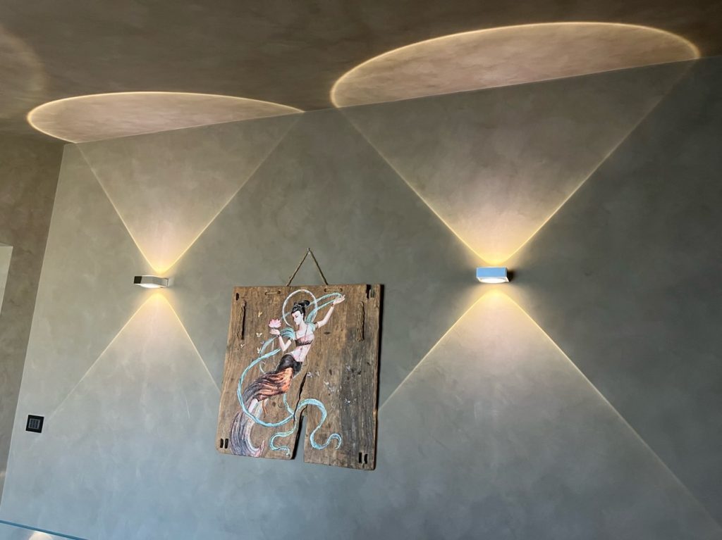 Interior wall with elegant lime-based finish by specialty contractors, featuring ambient lighting and decorative art.