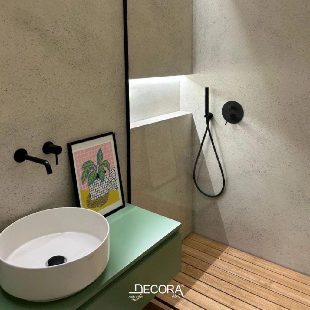 Microcement bathroom with modern black fixtures, vessel sink, and wood-style shower flooring by DECORA.