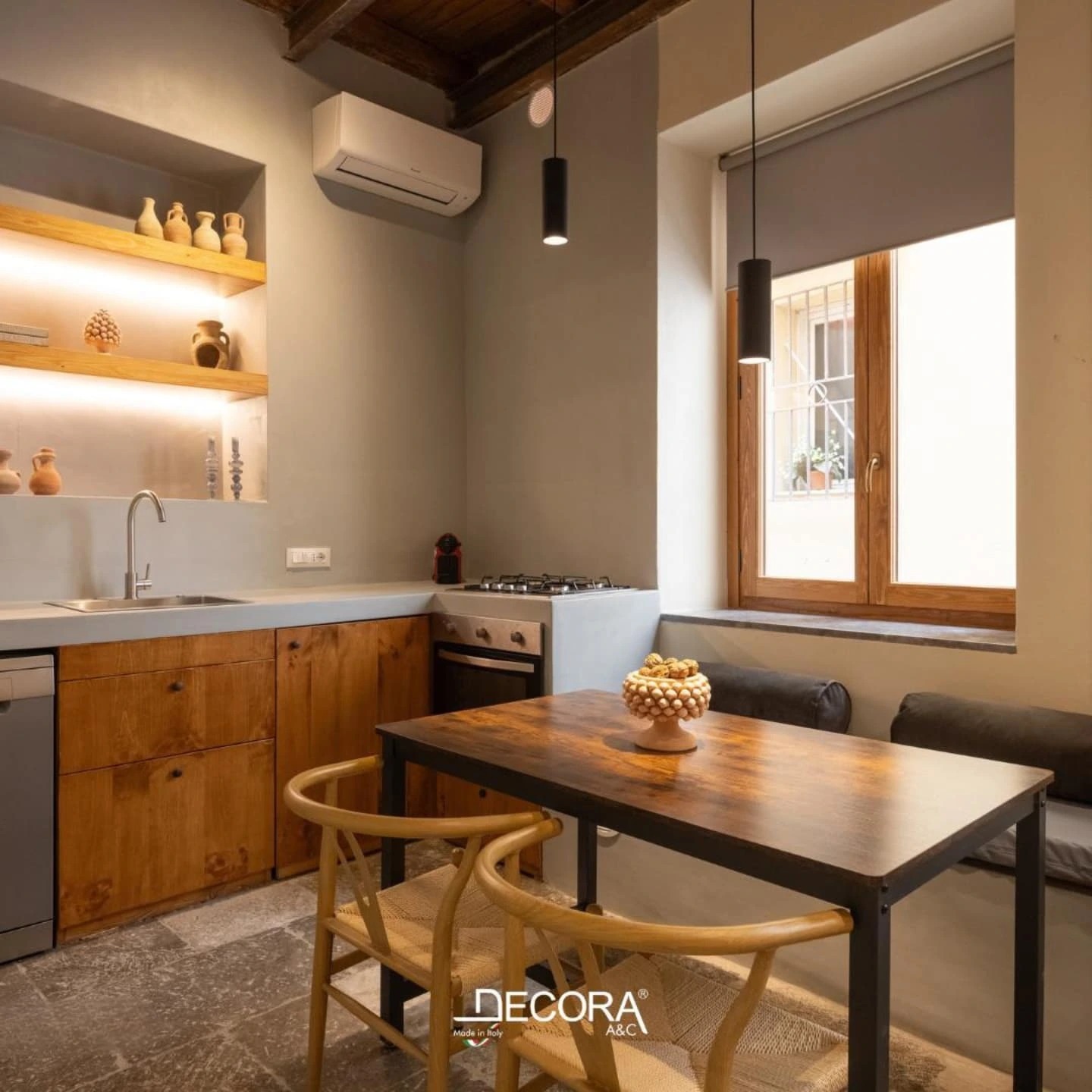 Modern kitchen with microcement walls, wooden cabinetry, stone flooring, and minimalist dining area by DECORA.