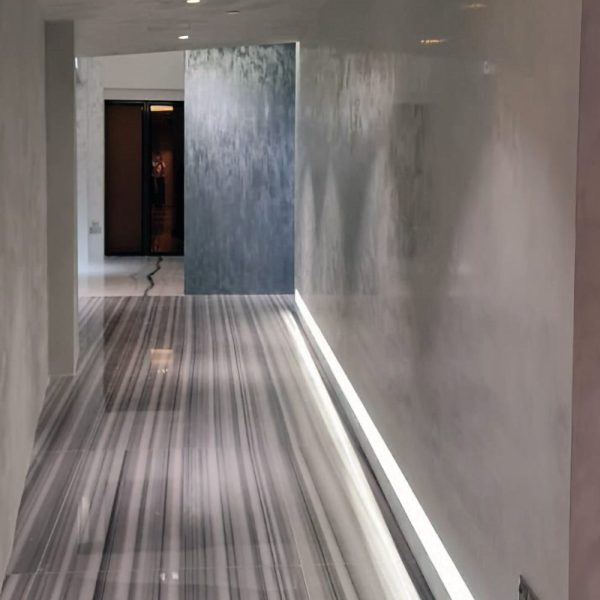 Luxury corridor with ISPEGU Stucco Lustro high-gloss lime plaster walls, marble flooring, and hidden LED lighting