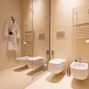 Minimalist bathroom with seamless light microcement walls and floors by Decora