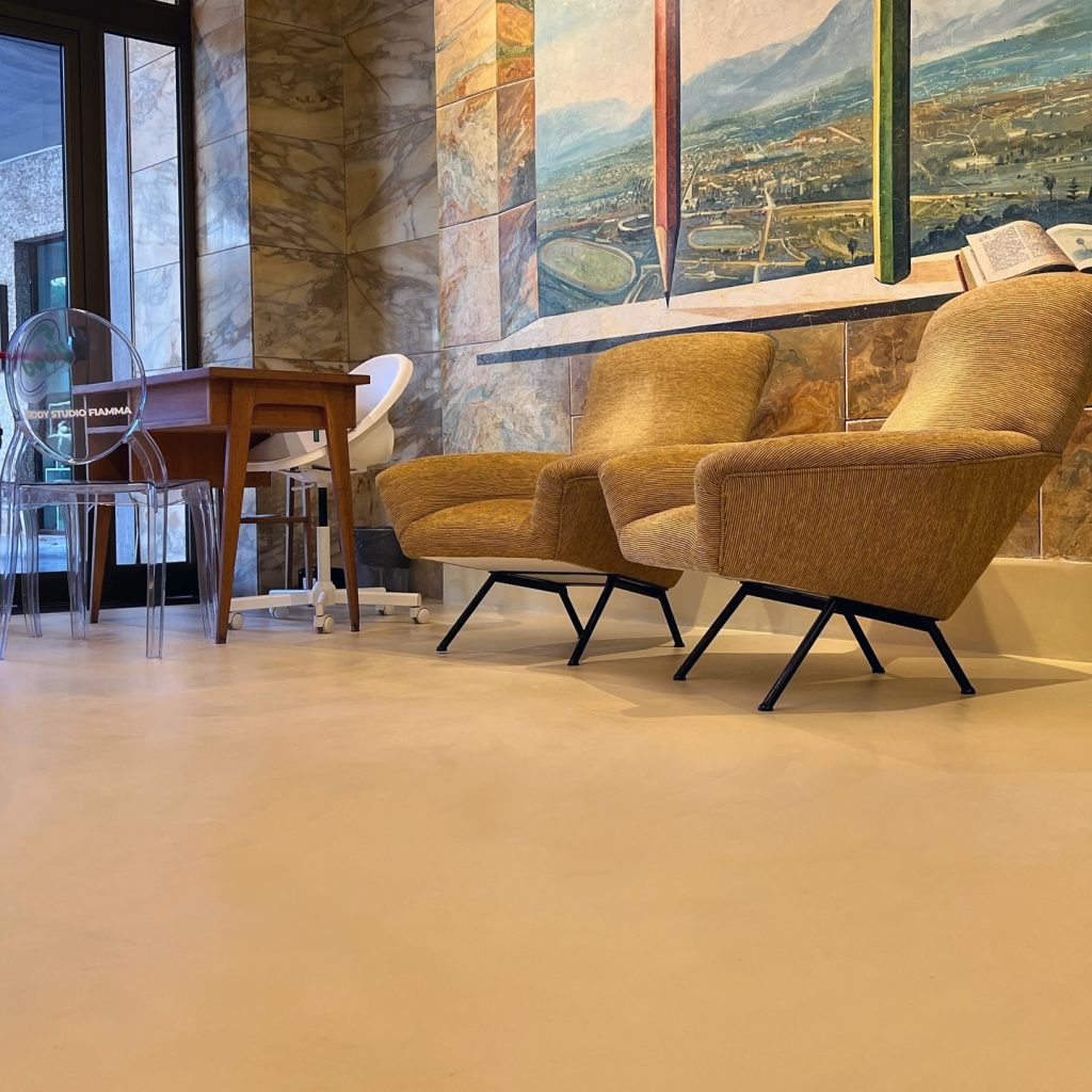 Seamless microcement floor by Decora at Palestre Body Studio in Cinema Fiamma with historic marble and mural details