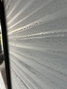 Close-up view of LUCE metallic wall texture with layered lime plaster in silver tones.