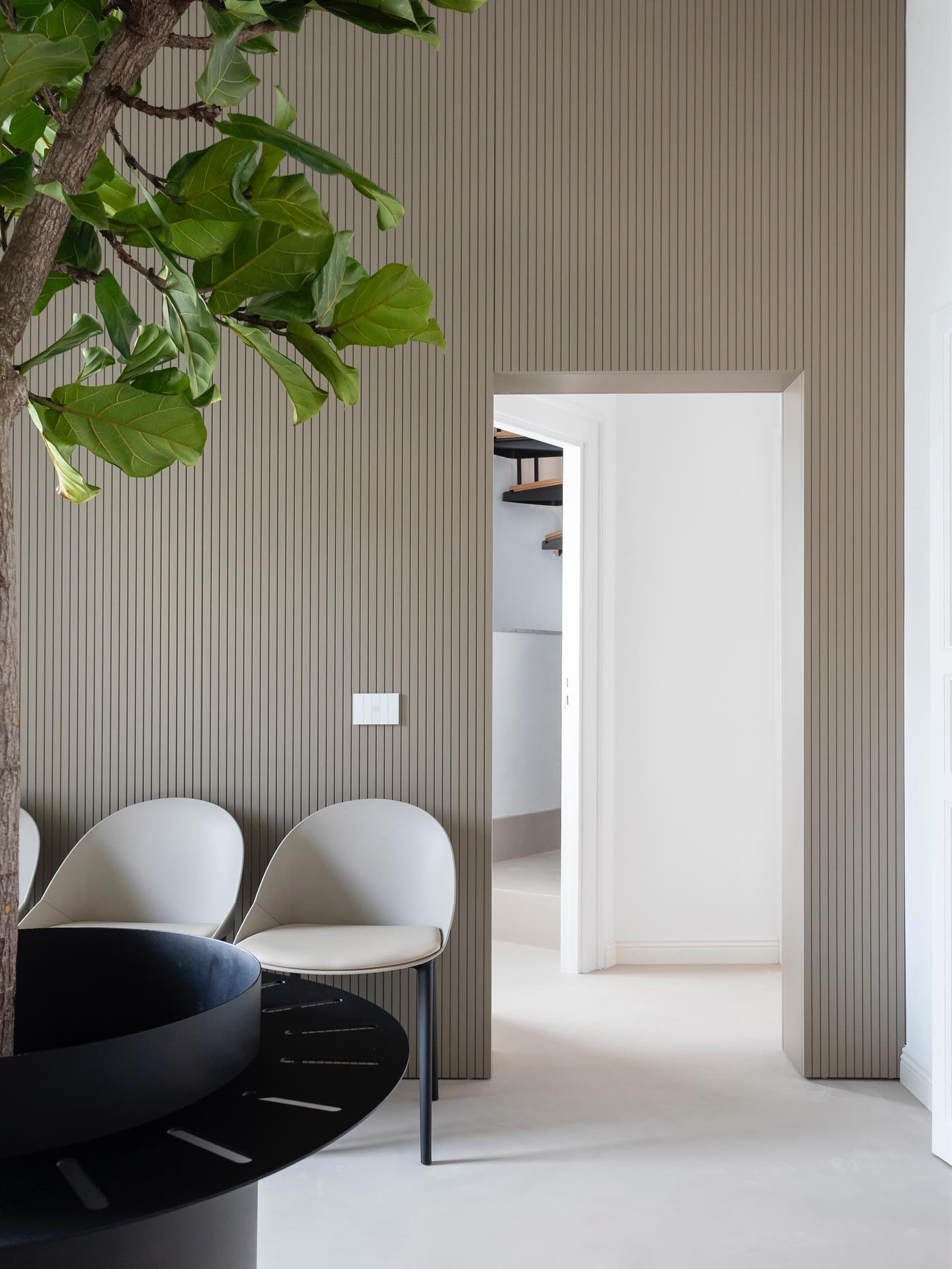 Contemporary workspace with textured walls, neutral tones, and Diamond System flooring by Decora A&C.