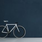 Minimalist room with white bicycle against a deep navy wall coated in Italian slaked lime paint by Decora A&C