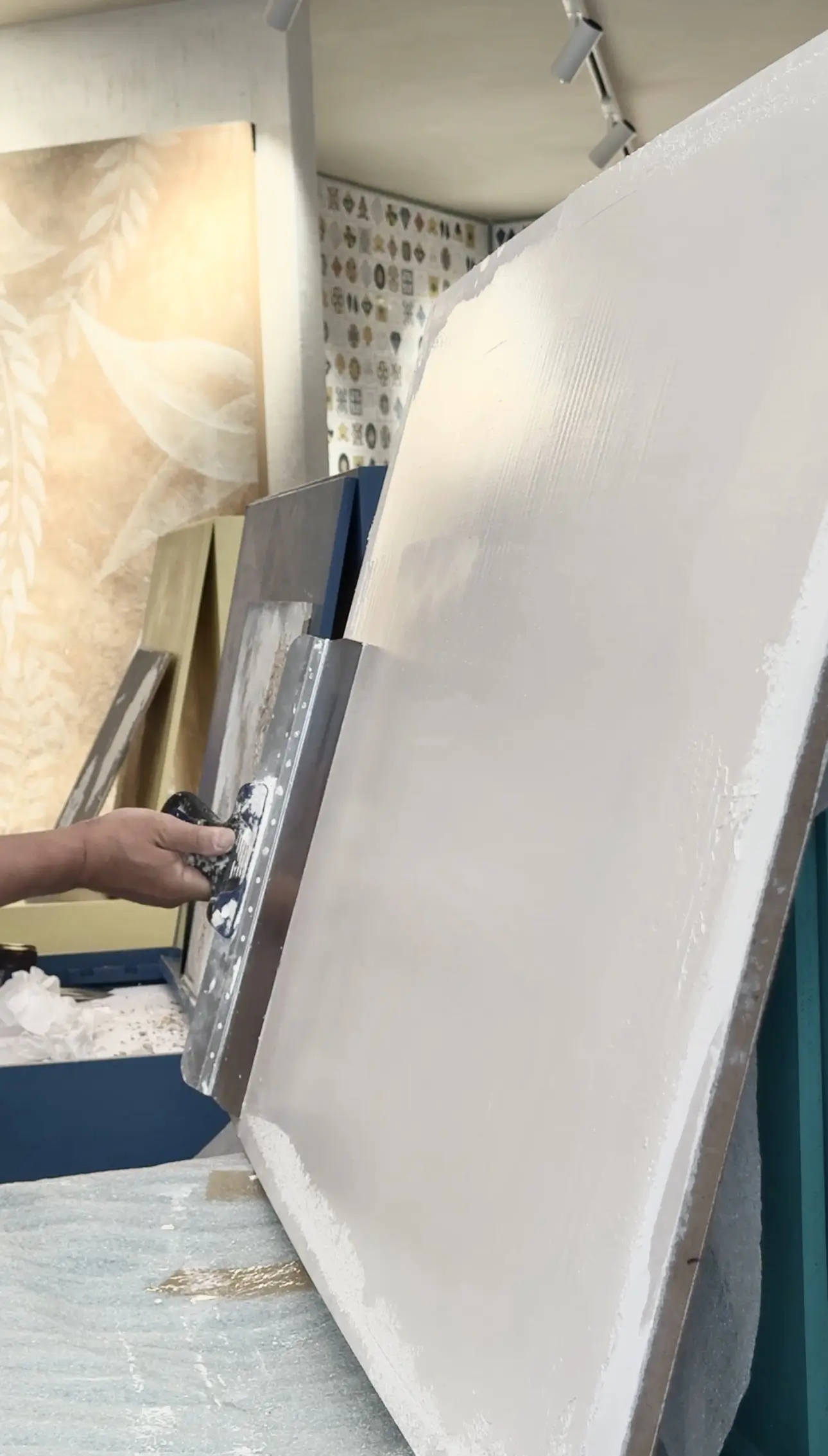 Applying high-quality plaster finish with trowel, showcasing Decora A&C’s craftsmanship.