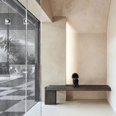 Minimalist Entryway With Textured Beige Walls and a Dark Wooden Bench